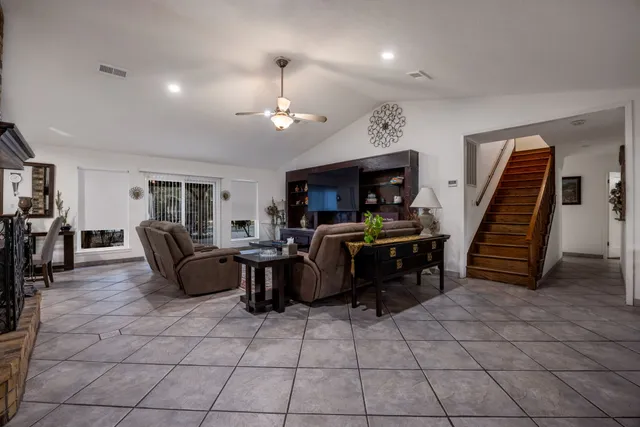 a living room with furniture a dining table and chairs with wooden floor