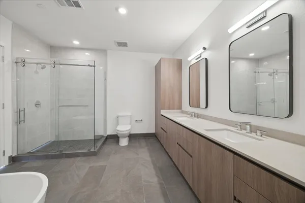 a bathroom with a double vanity sink mirror and toilet