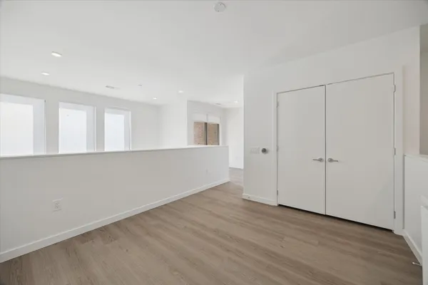 a view of an empty room with wooden floor