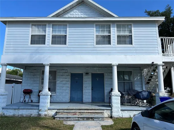 a front view of a house with garden and seating area