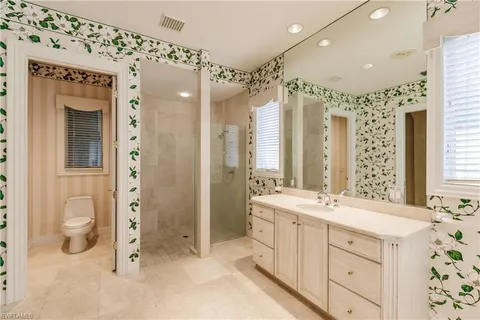 a spacious bathroom with a double vanity sink mirror and shower