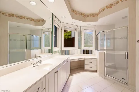 a large white bathroom with a granite countertop sink mirror and bathtub