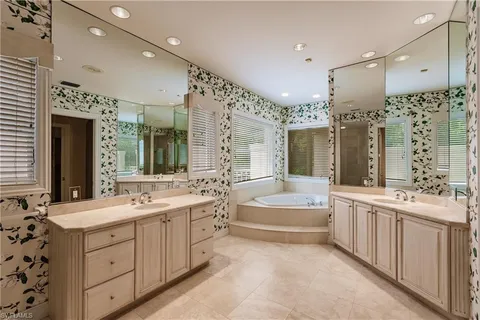 a bathroom with a double vanity sink mirror double and bathtub