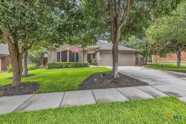 a front view of a house with a yard and trees