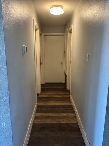 a view of a hallway with wooden floor and entryway