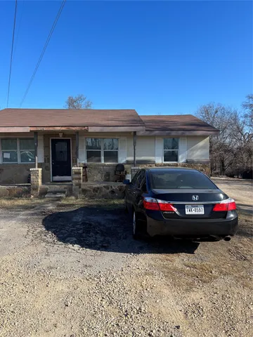 a front view of a house with cars parked