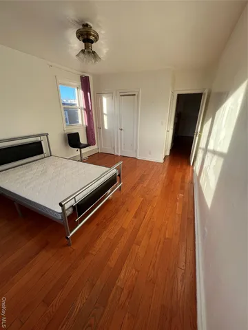 a room with wooden floor and ceiling fan