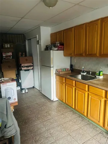 a kitchen with stainless steel appliances a sink a stove a refrigerator cabinets and a window