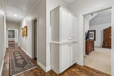 a view of a hallway with bathroom and wooden floor