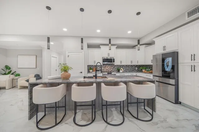 a large kitchen with a table and chairs