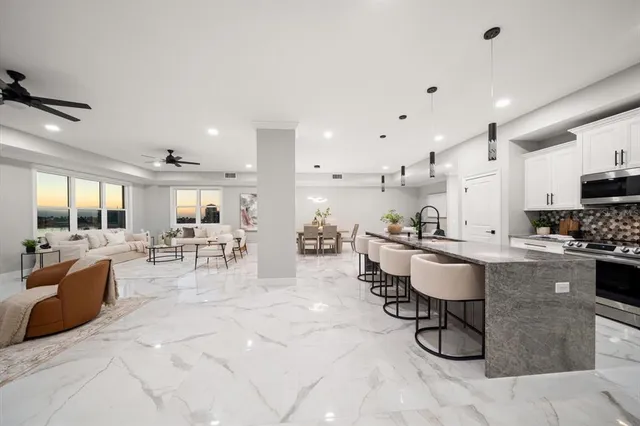 a living room with stainless steel appliances kitchen island granite countertop furniture and a view of kitchen