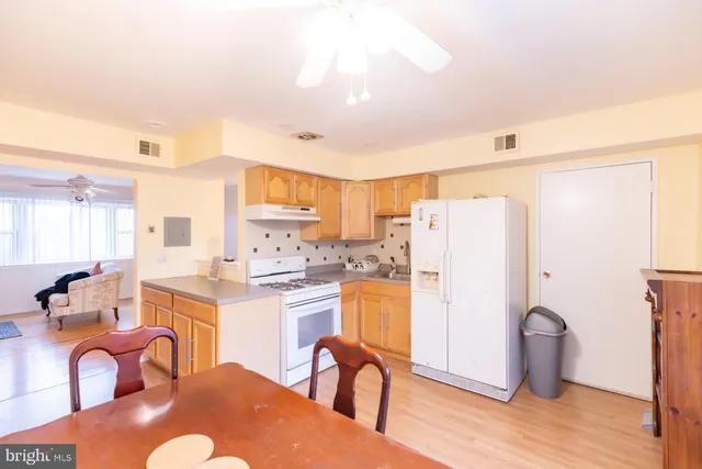 a kitchen with stainless steel appliances granite countertop a refrigerator a stove a sink dishwasher with a dining table and chairs