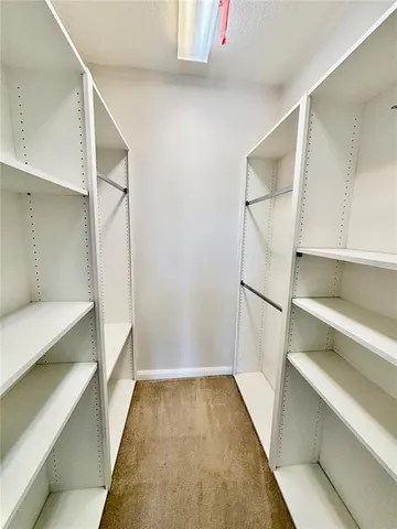a view of walk in closet with empty racks