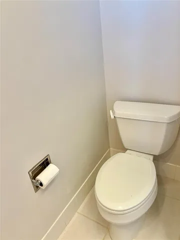 a white toilet sitting next to a white wall