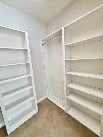 a view of walk in closet with empty racks