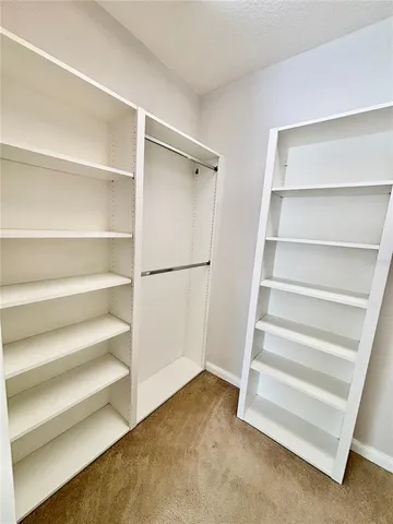 a view of walk in closet with empty racks