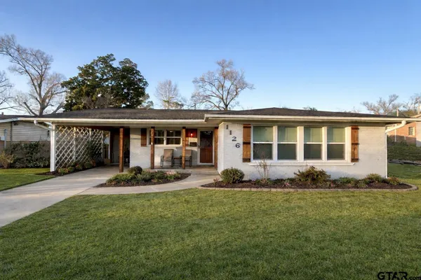 a front view of a house with a garden and yard