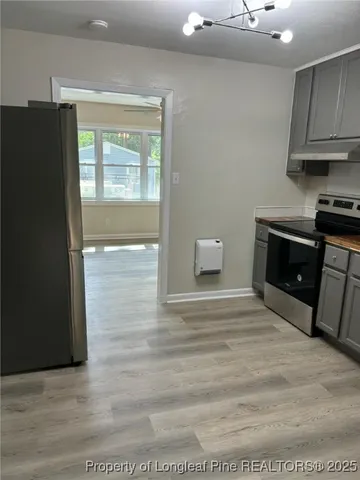 a view of kitchen with granite countertop cabinets and refrigerator
