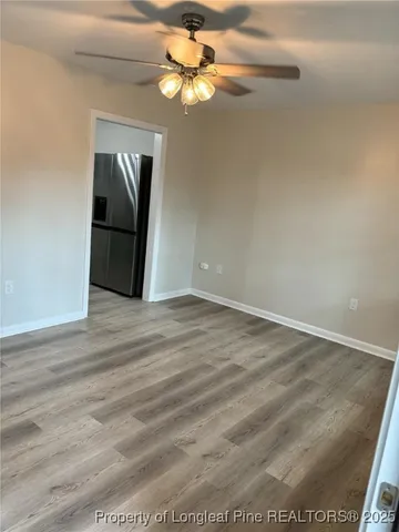 a view of a livingroom with wooden floor and a ceiling fan