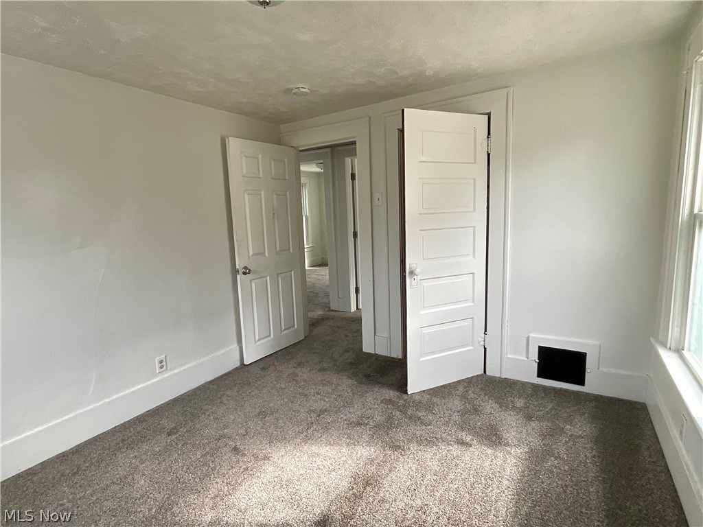425 Spaulding Street Akron, OH 44310 - Photo 8 of 17 Unfurnished bedroom featuring a textured ceiling, carpet flooring, and a closet