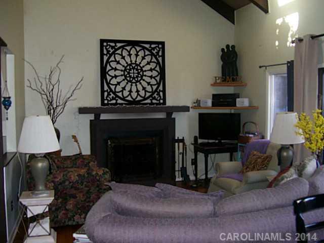 4723 Rounding Run Road, Unit 5 Charlotte, NC 28277 - Photo 2 of 12 a living room with furniture a fireplace and a flat screen tv