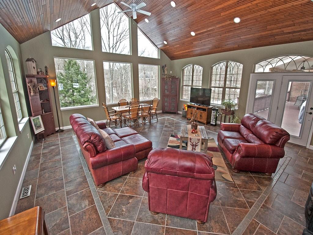 835 Old Mill Road Fox Chapel, PA 15238 - Photo 11 of 25 The room is fantastic. Large windows, custom wood vaulted ceiling, imported ceramic floors with platinum inserts. Doors leading out to the covered trex deck. Stone wall with a stove fireplace.