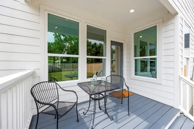 a balcony with chairs and wooden floor