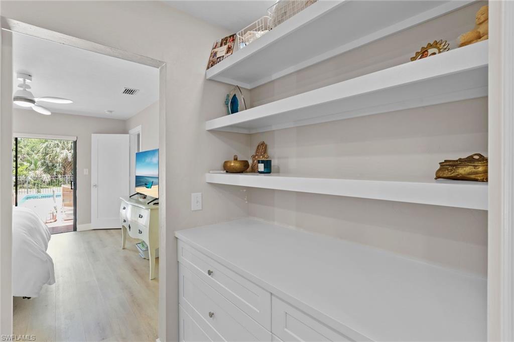 3221 68th Street Southwest Naples, FL 34105 - Photo 17 of 38 a hallway with white cabinets and wooden floor