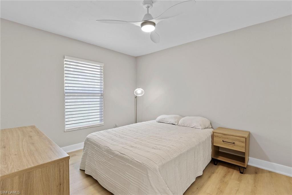 3221 68th Street Southwest Naples, FL 34105 - Photo 21 of 38 a bedroom with a bed and a night stand