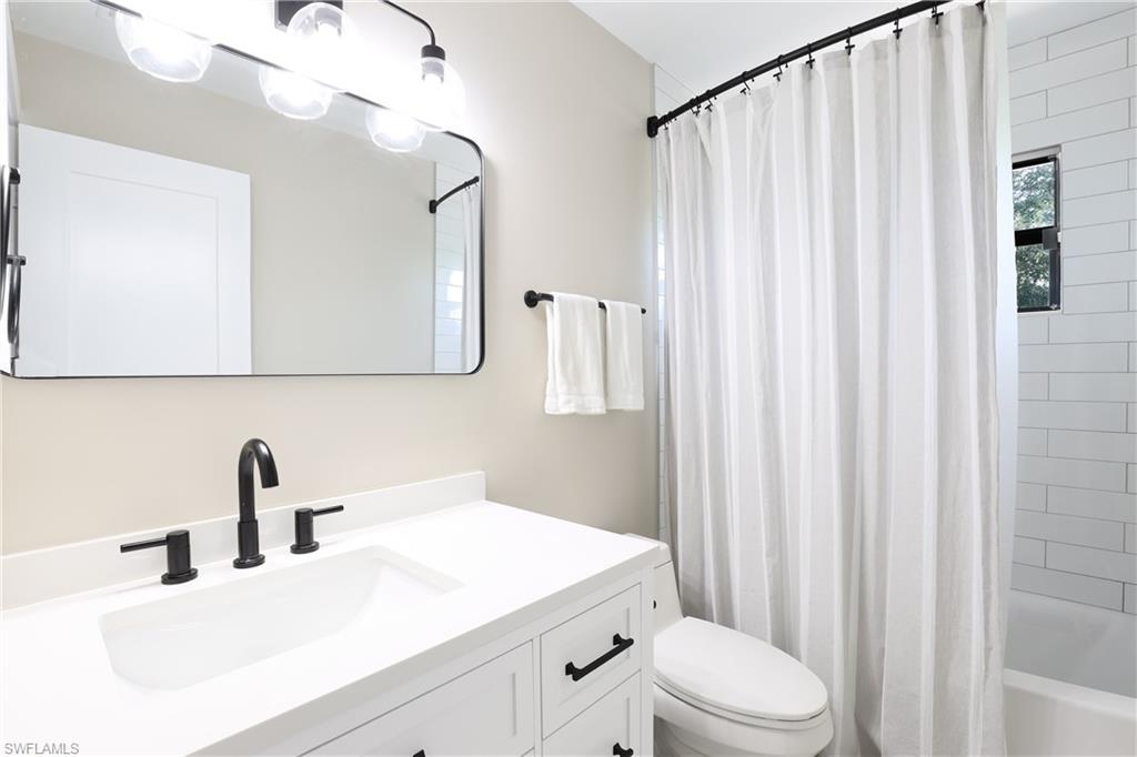 3221 68th Street Southwest Naples, FL 34105 - Photo 22 of 38 a bathroom with a sink a toilet and shower curtain