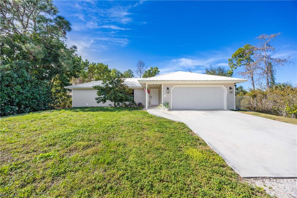 3221 68th Street Southwest Naples, FL 34105 - Photo 33 of 38 a white house with a yard and potted plants