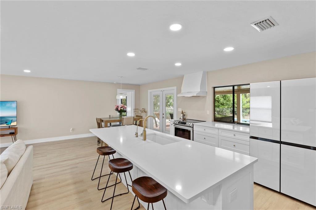 3221 68th Street Southwest Naples, FL 34105 - Photo 7 of 38 a large kitchen with a table and chairs in it
