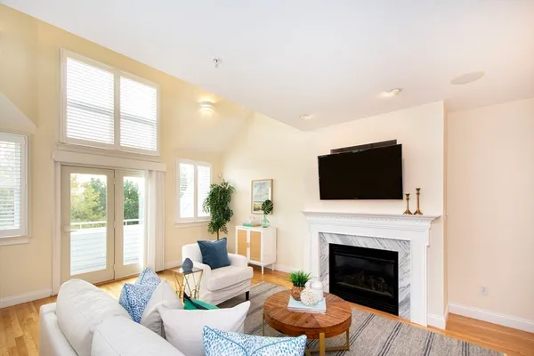 a living room with furniture a flat screen tv and a fireplace