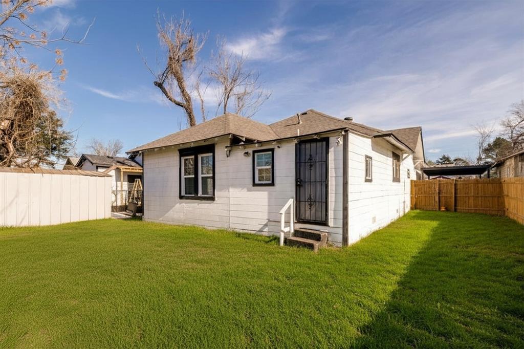 2317 Anderson Street Dallas, TX 75215 - Photo 12 of 14 Rear view of house featuring a fenced backyard, entry steps, and roof with shingles
