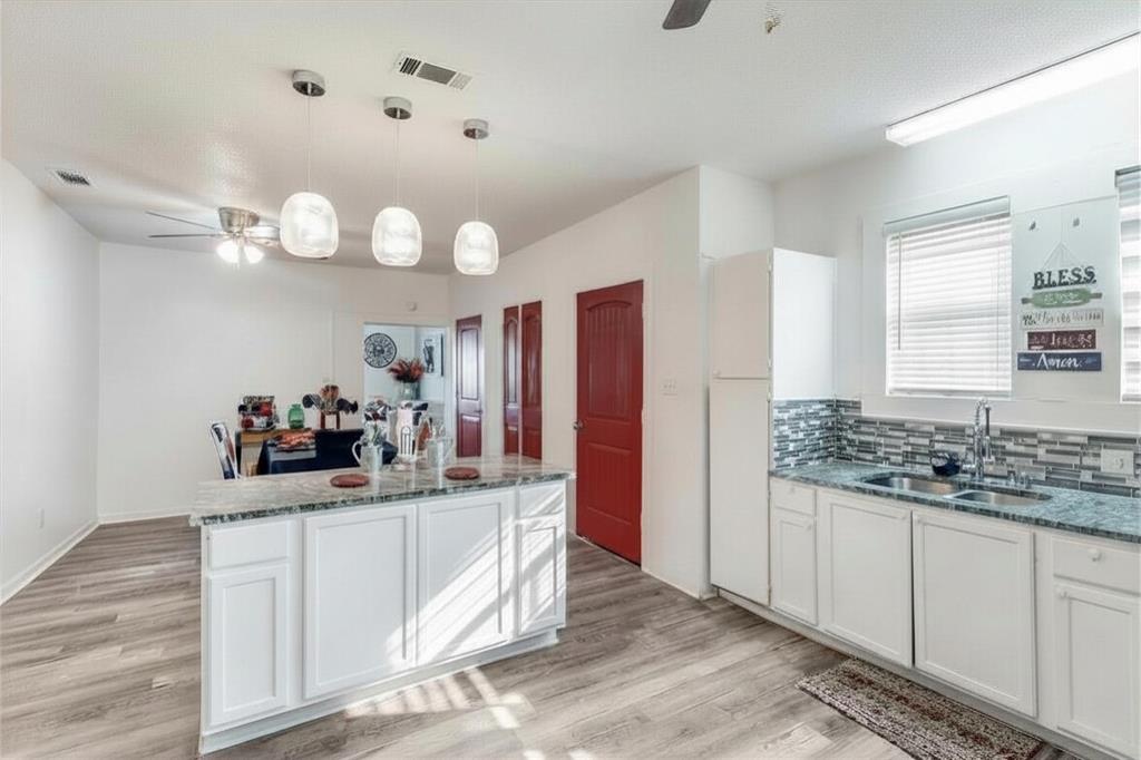 2317 Anderson Street Dallas, TX 75215 - Photo 5 of 14 Kitchen featuring a ceiling fan, white cabinets, and light stone counters