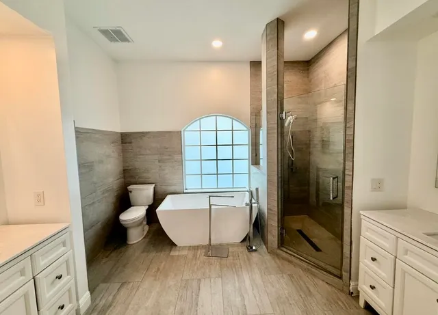a bathroom with a toilet a sink and glass door
