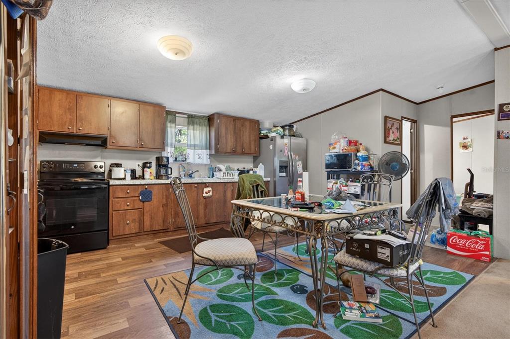 5083 Southeast 70th Loop Ocala, FL 34480 - Photo 11 of 34 a kitchen with stainless steel appliances granite countertop a stove a refrigerator a sink dishwasher and white cabinets with wooden floor