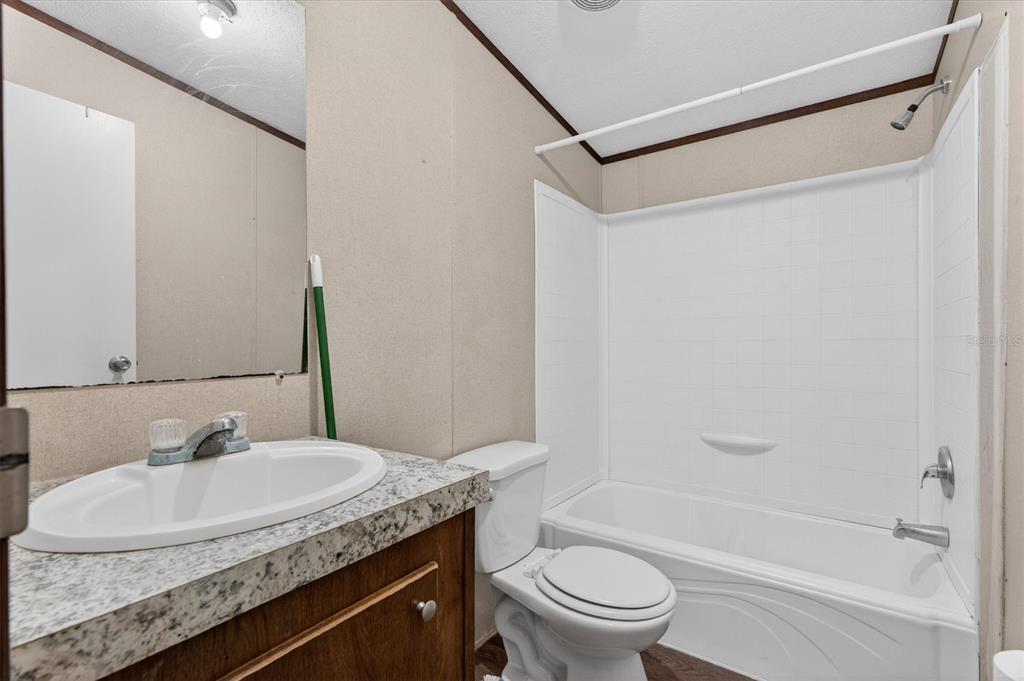 5083 Southeast 70th Loop Ocala, FL 34480 - Photo 14 of 34 a bathroom with a granite countertop sink toilet and shower