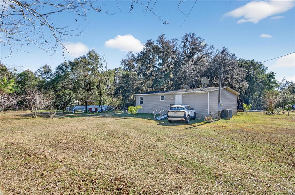 5083 Southeast 70th Loop Ocala, FL 34480 - Photo 21 of 34 a view of a house with a yard and garage