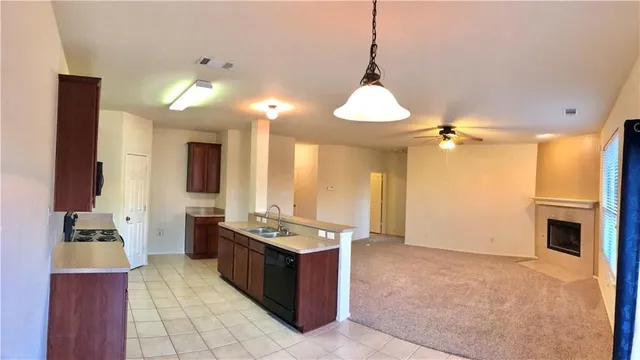 a dining hall with stainless steel appliances granite countertop a sink and a cabinets