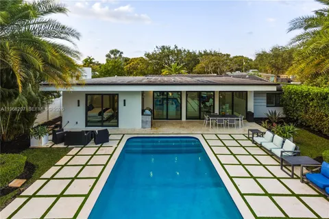 a view of a house with a swimming pool and a yard