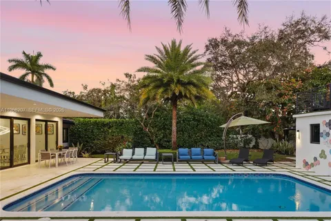 a kitchen with stainless steel appliances kitchen island granite countertop a table chairs and a refrigerator