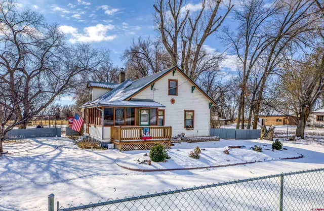 a view of a white house with a yard covered in snow