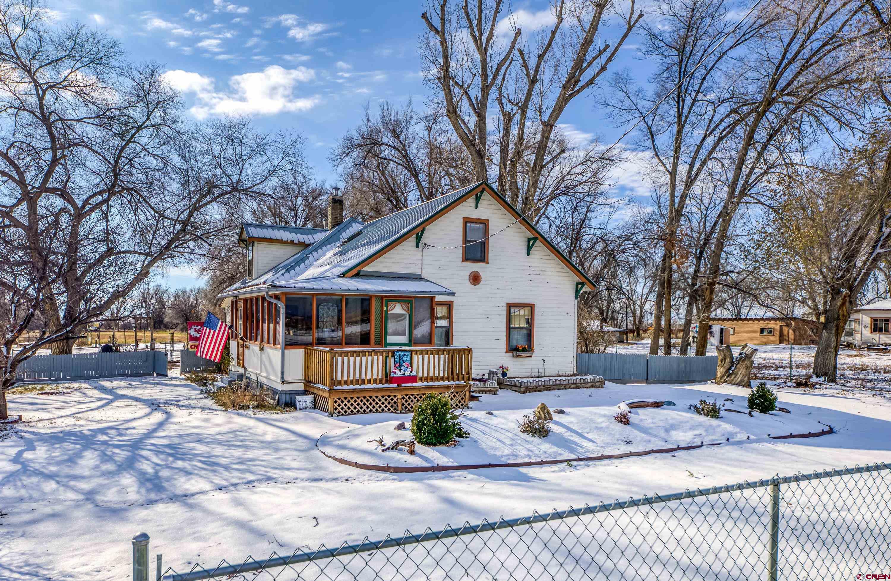 a view of a white house with a yard covered in snow