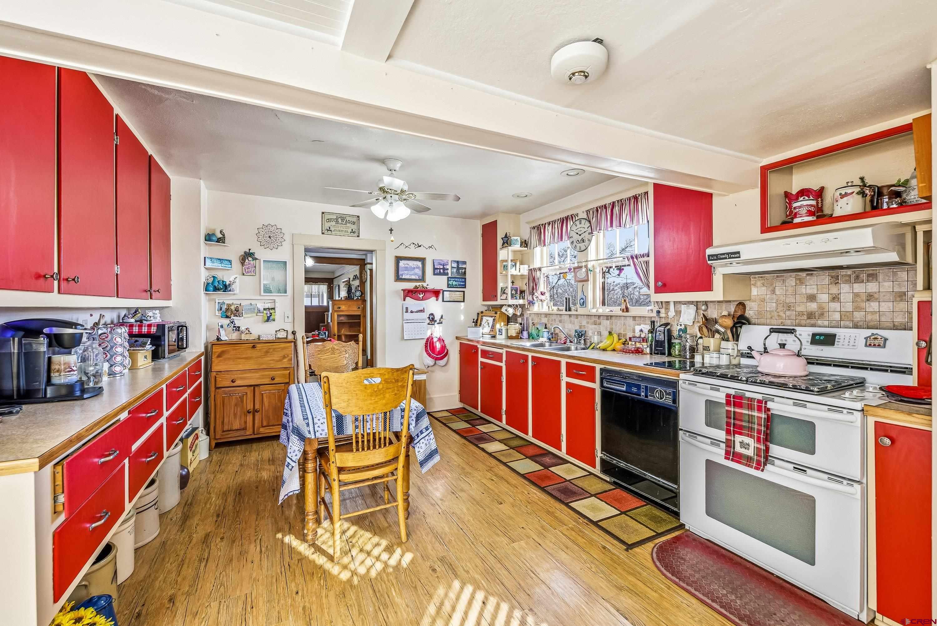 21568 Austin Road Austin, CO 81410 - Photo 13 of 37 a kitchen with stainless steel appliances a stove a sink dishwasher and cabinets with wooden floor
