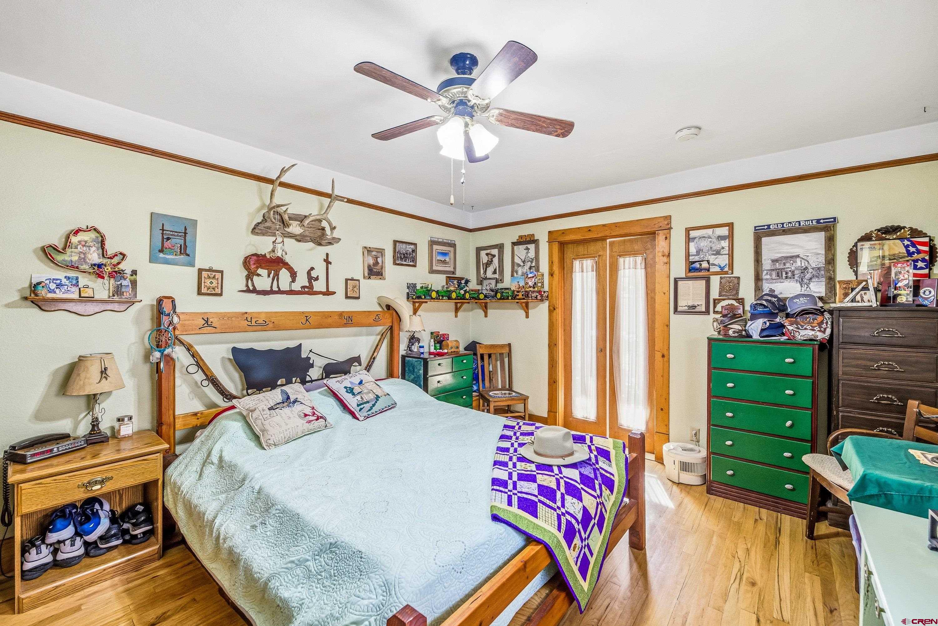 21568 Austin Road Austin, CO 81410 - Photo 16 of 37 a bed room with a bed and a chandelier