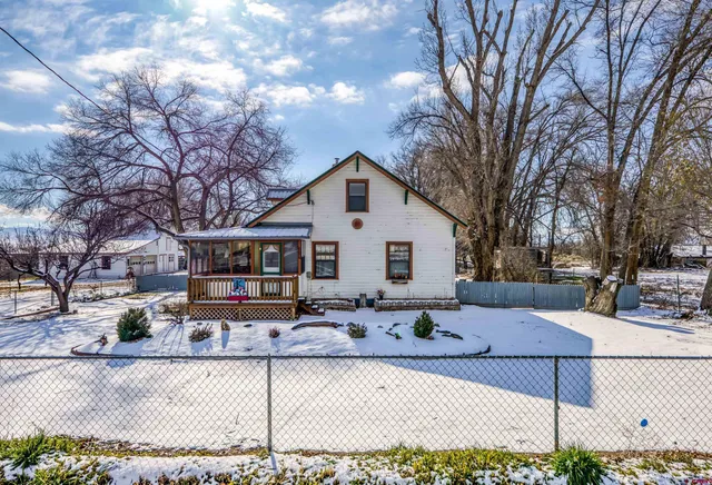 a front view of house with yard covered in snow
