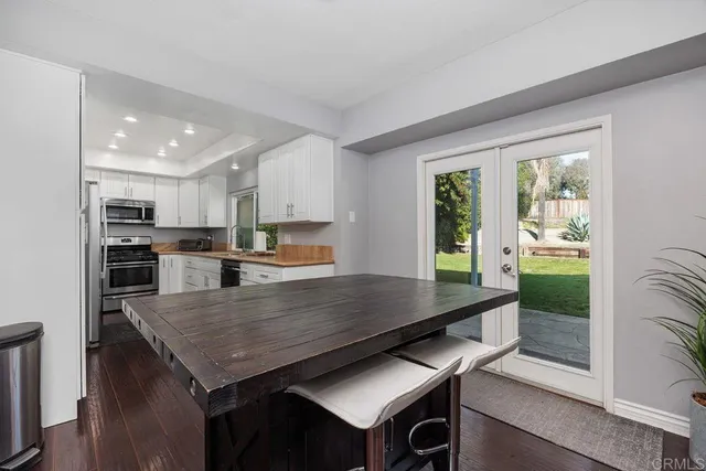 a kitchen with granite countertop a stove kitchen island and living room