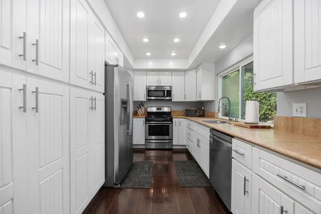 a large kitchen with stainless steel appliances granite countertop a stove a sink and a refrigerator