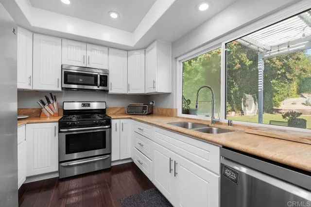 a kitchen with stainless steel appliances a stove sink microwave and cabinets